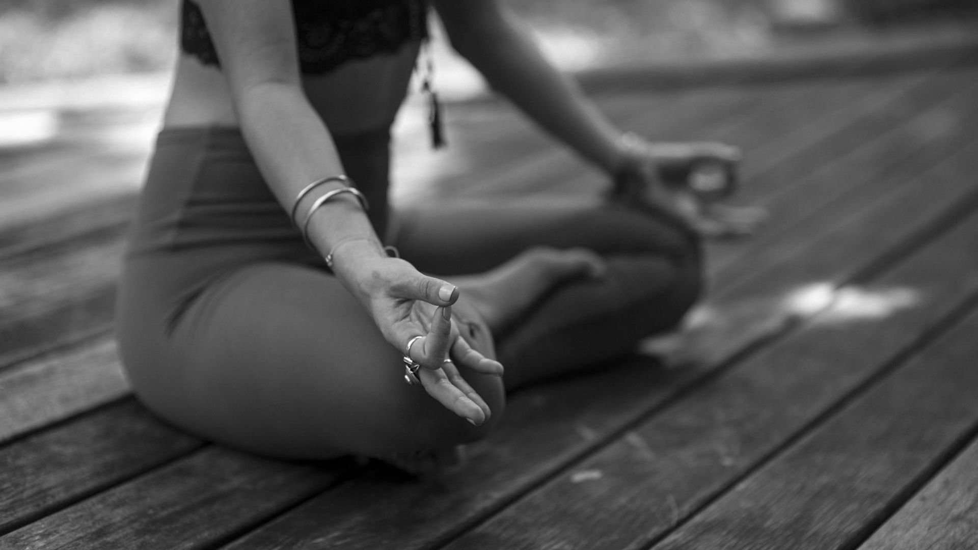 Person practicing yoga stability poses in a dark studio.